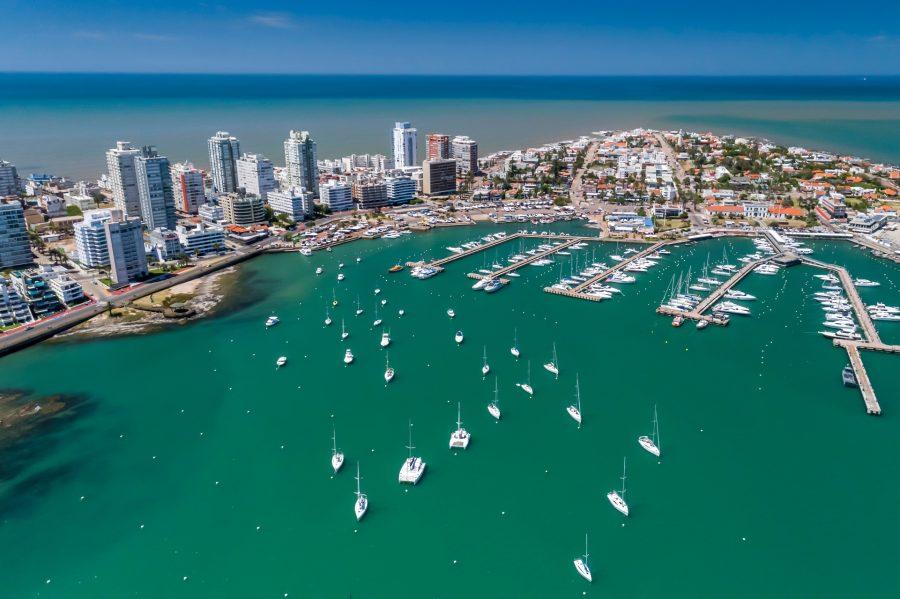 Harbor city on a turquoise coast with numerous anchored yachts and sailing boats. In the background, modern skyscrapers. A perfect starting point for popular cruise routes in South America.
